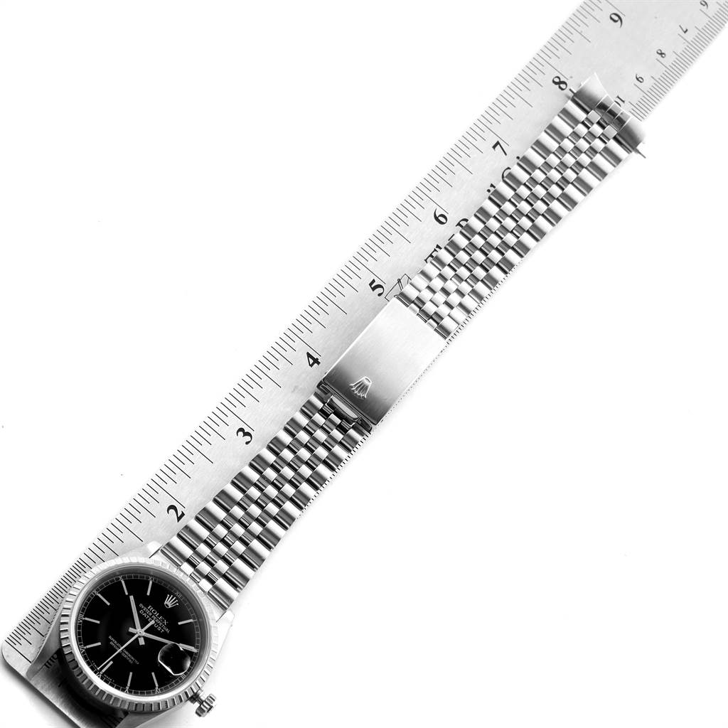 The image shows a Rolex Datejust 16220 Men's Stainless Steel Black Dial 16220 Men's Stainless Steel Black Dial watch lying flat, with the face, bracelet, and clasp visible, alongside a ruler measuring its length.