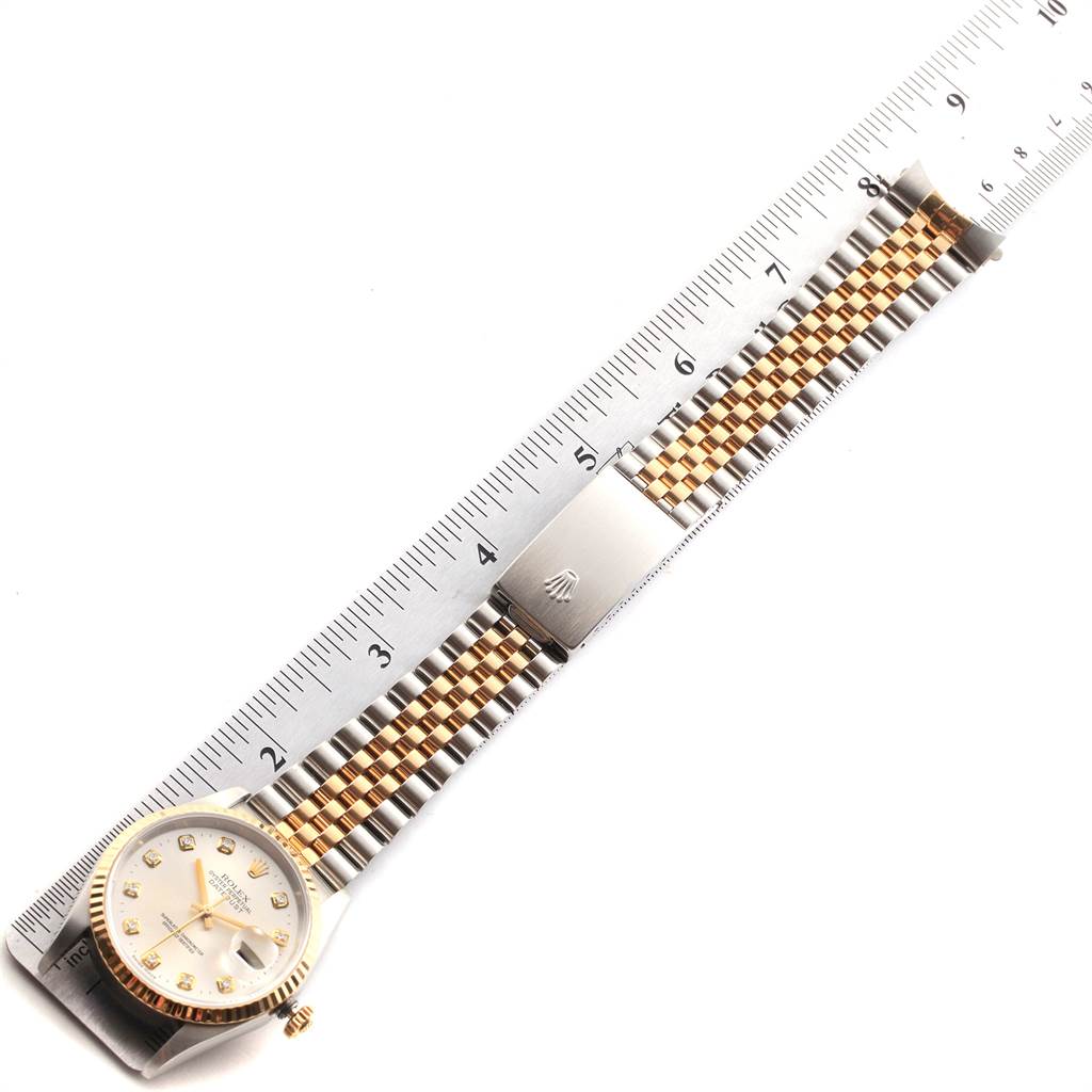 The image shows a top-view angle of a Rolex Datejust 16233 Men's Steel and Gold (two tone) Silver Dial 16233 Men's Steel and Gold (two tone) Silver Dial watch with a jubilee two-tone bracelet, laying next to a ruler for scale.
