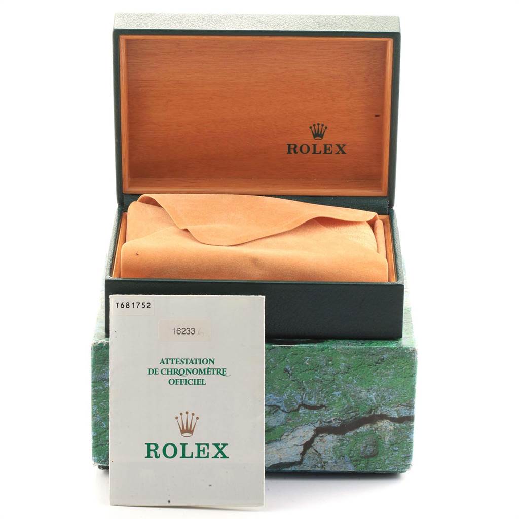 The image shows an open green Rolex box with an orange cloth inside and a booklet standing in front, indicating the Datejust model.