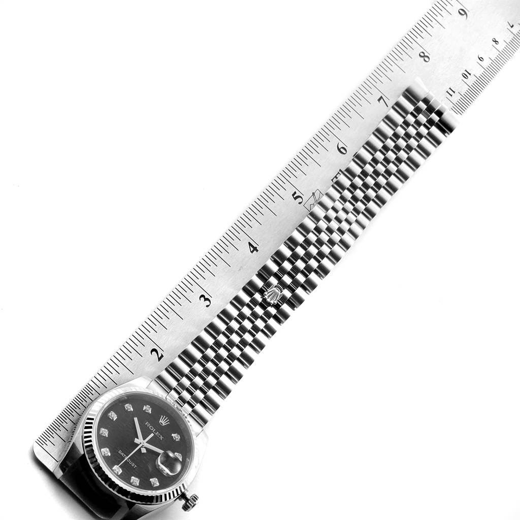 The image shows a top-down view of a Rolex Datejust 116234 Men's Stainless Steel Black Dial 116234 Men's Stainless Steel Black Dial watch face and part of its metal bracelet, measured next to a ruler.