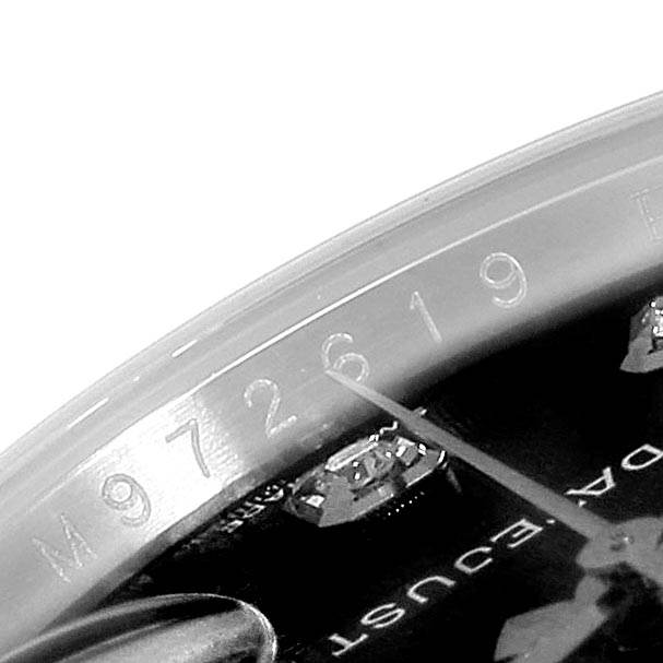 The image shows a close-up of the serial number engraving and part of the dial on a Rolex Datejust 116234 Men's Stainless Steel Black Dial 116234 Men's Stainless Steel Black Dial watch.