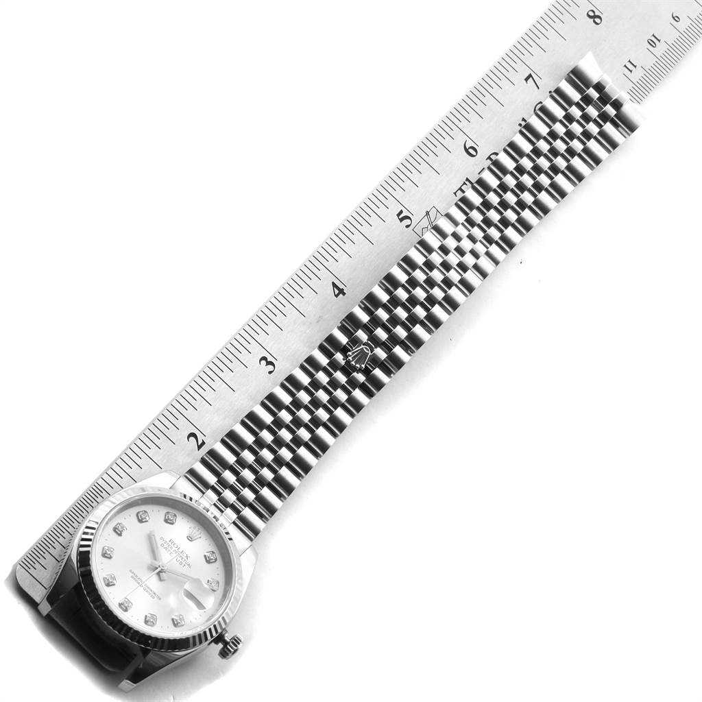 The image shows a top view of a Rolex Datejust 116234 Men's Stainless Steel Silver Dial 116234 Men's Stainless Steel Silver Dial watch with a ruler measuring its bracelet.