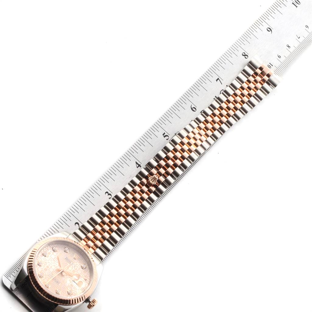 This image shows a Rolex Datejust 116231 Men's Steel and Gold (two tone) Pink Dial 116231 Men's Steel and Gold (two tone) Pink Dial watch with a focus on the bracelet alongside a ruler for measurement.