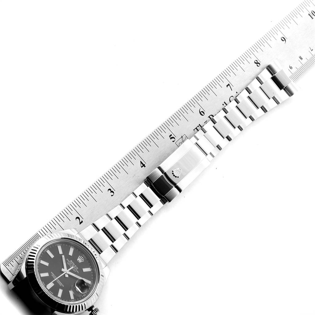 The image shows a top-down view of a Rolex Datejust 116334 Men's Stainless Steel Black Dial 116334 Men's Stainless Steel Black Dial watch, highlighting its bracelet and clasp alongside a ruler for scale.