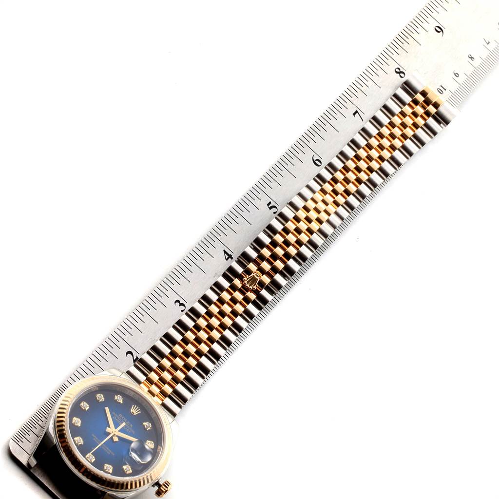 The watch is a Rolex Datejust 116233 Men
s Steel and Gold (two tone) Blue Dial 116233 Men
s Steel and Gold (two tone) Blue Dial model, showing the dial and bracelet with a ruler for measurement.