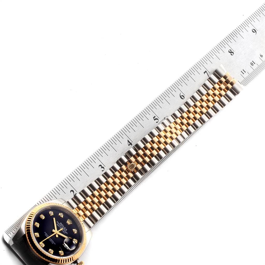 The image shows a Rolex Datejust 116233 Men's Stainless Steel Black Dial 116233 Men's Stainless Steel Black Dial watch laying flat with a ruler measuring its bracelet length.