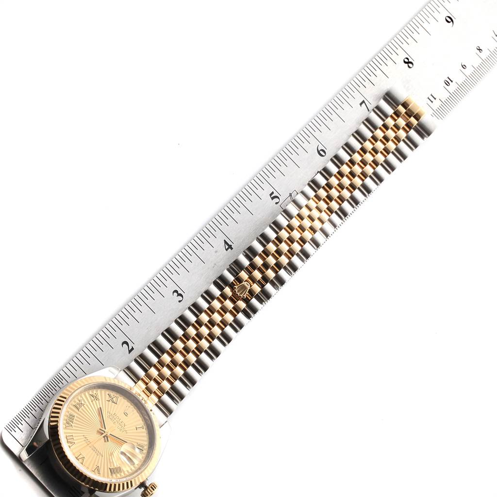 The image shows the side view of a Rolex Datejust 116233 Men's Stainless Steel Champagne Dial 116233 Men's Stainless Steel Champagne Dial watch, focused on the dial, bezel, and partially extended jubilee bracelet next to a ruler.