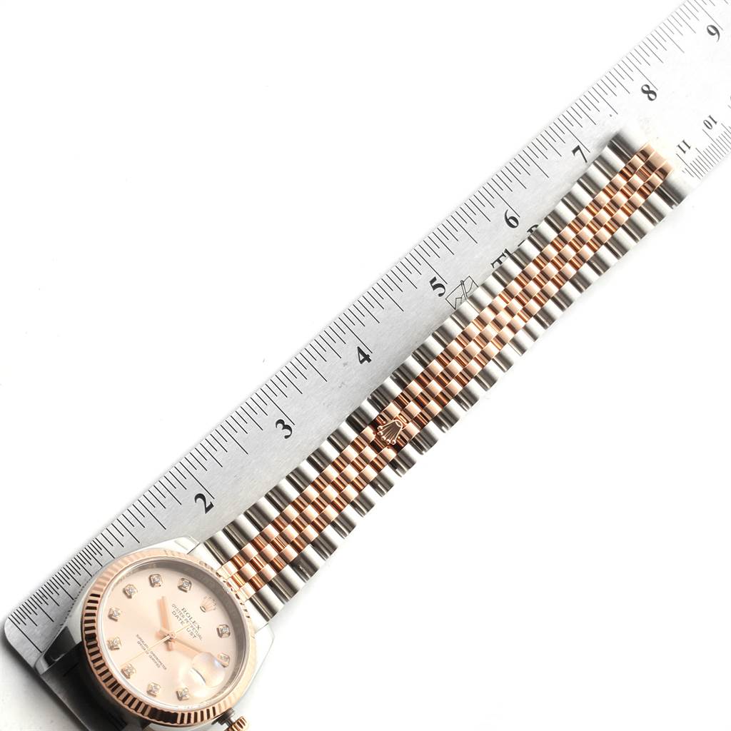 The image shows a Rolex Datejust 116231 Men's Steel and Gold (two tone) Pink Dial 116231 Men's Steel and Gold (two tone) Pink Dial watch laid flat with its face and band fully visible, along with a ruler for scale.