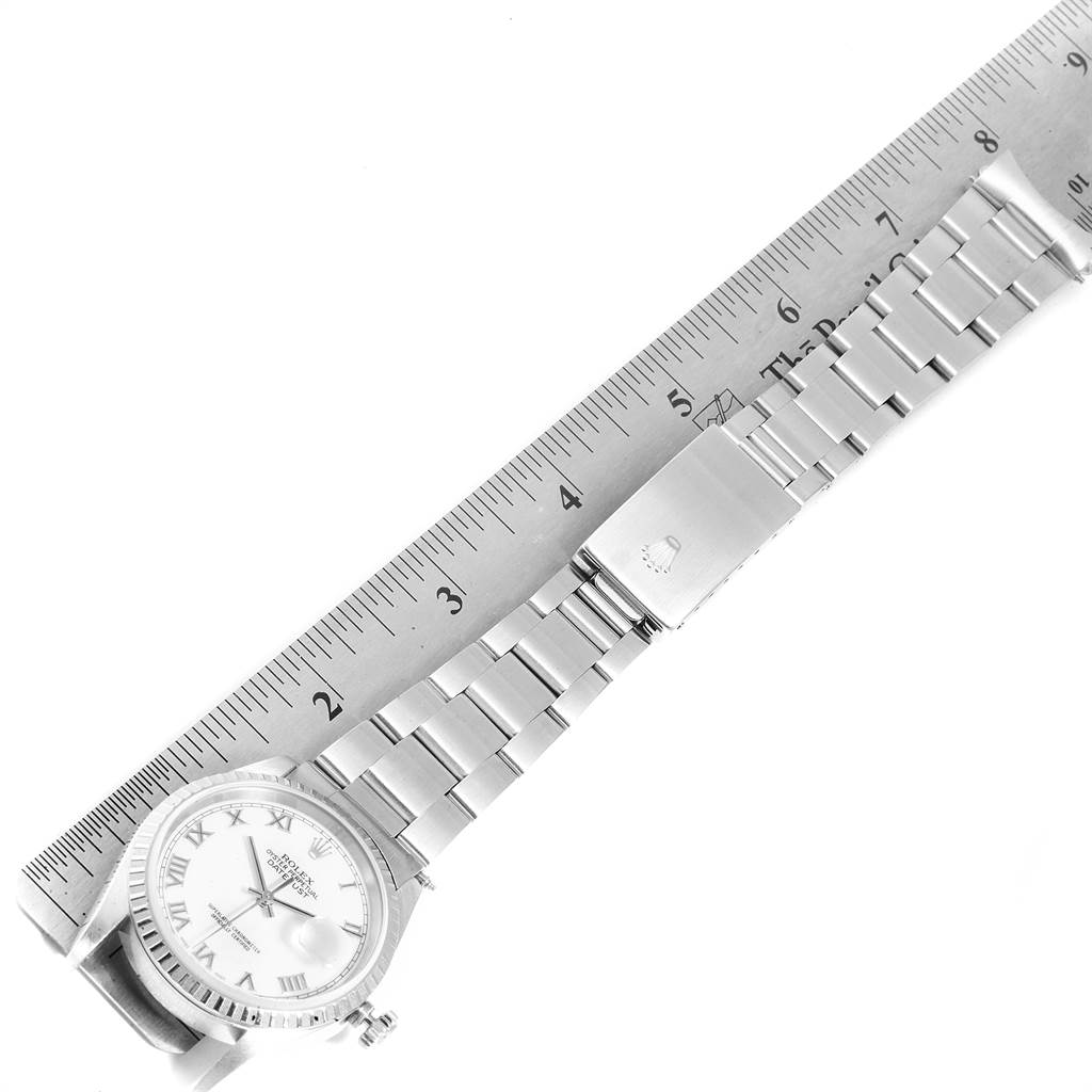 The image shows a top-down view of a Rolex Datejust 16220 Men's Stainless Steel White Dial 16220 Men's Stainless Steel White Dial watch, featuring the dial, bracelet, and clasp beside a ruler.