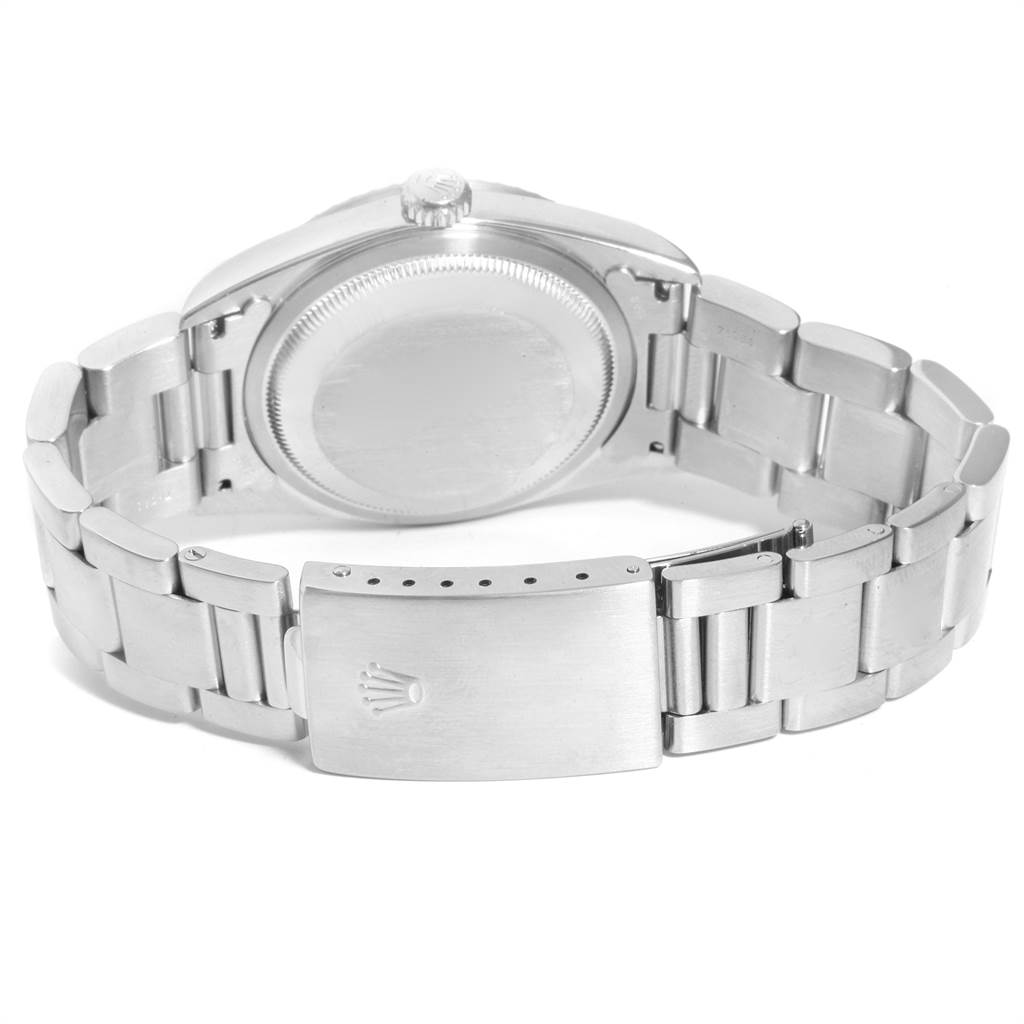 The image shows the underside view of the Rolex Datejust 16220 Men's Stainless Steel White Dial 16220 Men's Stainless Steel White Dial watch, including its caseback, crown, and bracelet with a clasp.