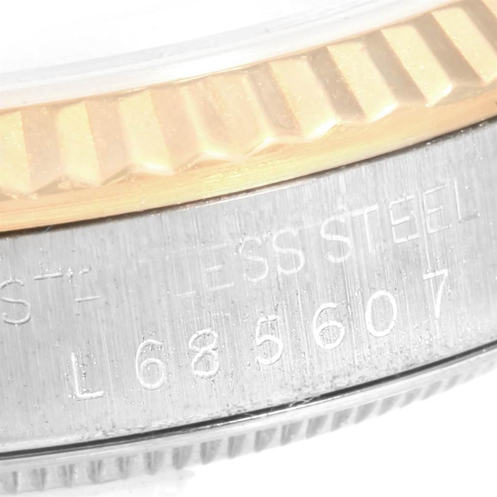 This image shows a close-up of the Rolex Datejust 16233 Men's Steel and Gold (two tone) Champagne Dial 16233 Men's Steel and Gold (two tone) Champagne Dial watch's bezel and part of the case with engraved text.