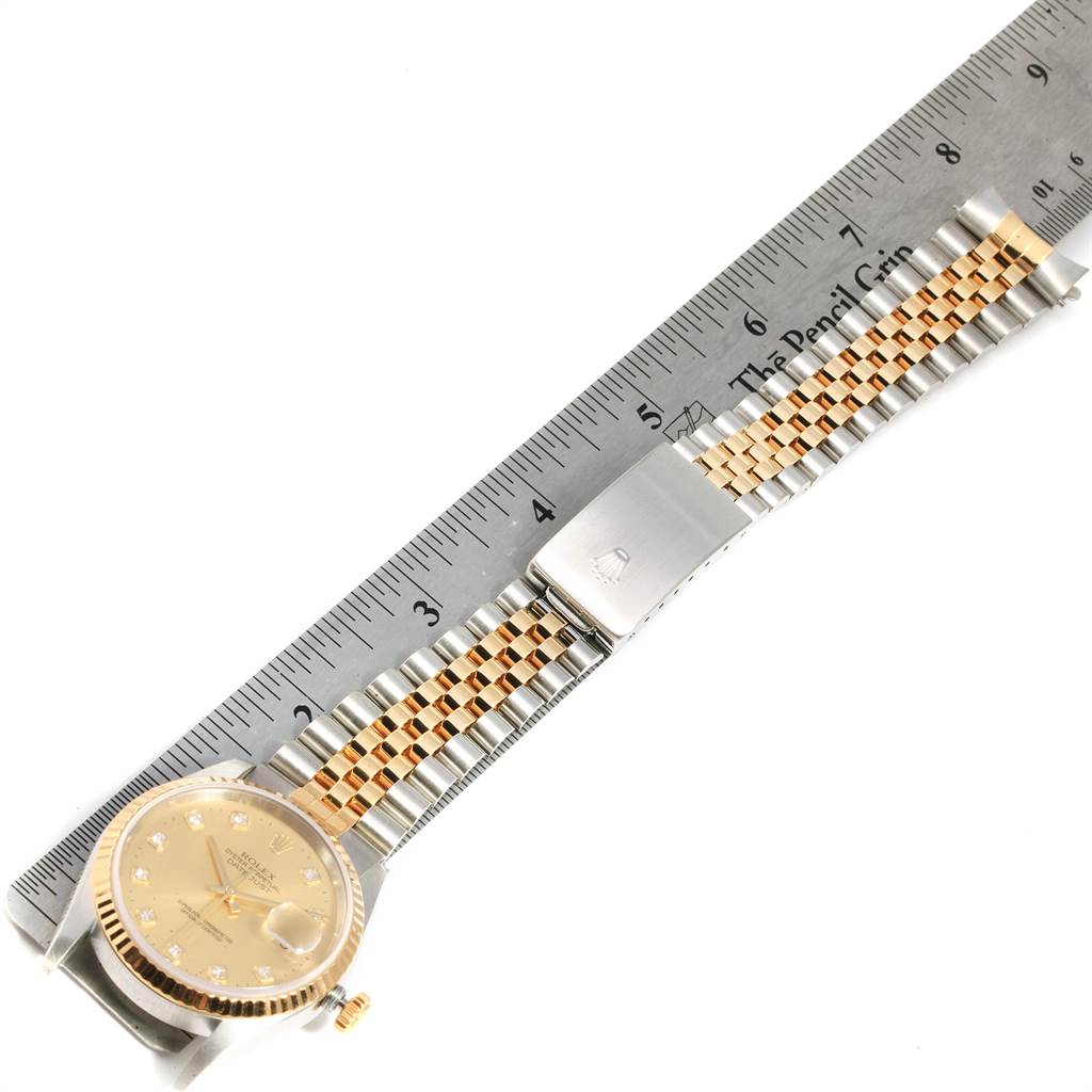 The image shows a Rolex Datejust 16233 Men's Steel and Gold (two tone) Champagne Dial 16233 Men's Steel and Gold (two tone) Champagne Dial watch laid flat with its gold and silver bracelet alongside a ruler for measurement.