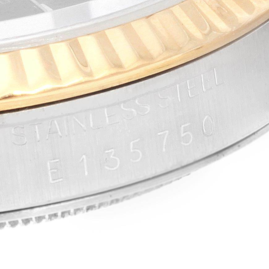 The image shows a close-up of the gold and stainless steel bezel and case edge of a Rolex Datejust 16233 Men
s Steel and Gold (two tone) Black Dial 16233 Men
s Steel and Gold (two tone) Black Dial watch, with engraved details.
