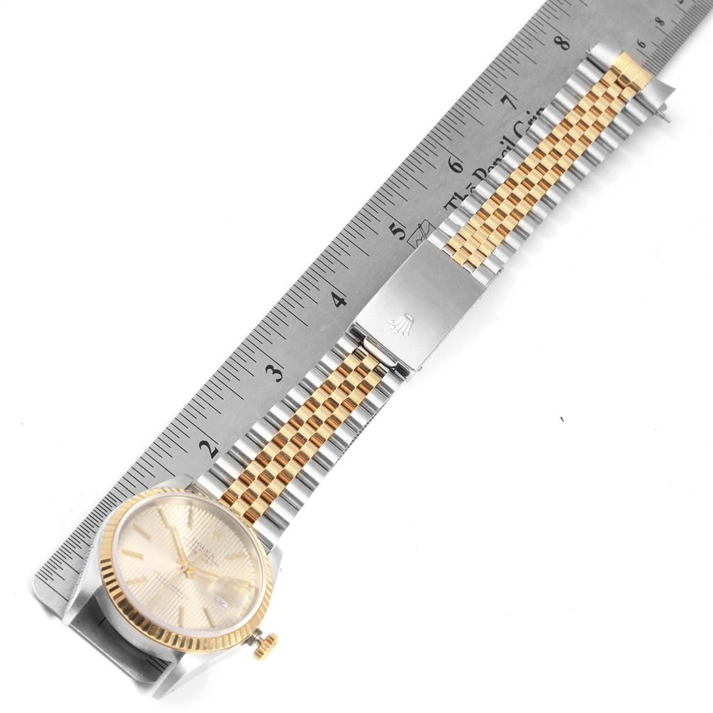 The image shows a top view of a Rolex Datejust 16233 Men's Steel and Gold (two tone) Silver Dial 16233 Men's Steel and Gold (two tone) Silver Dial watch with its jubilee bracelet and a ruler for measurement.