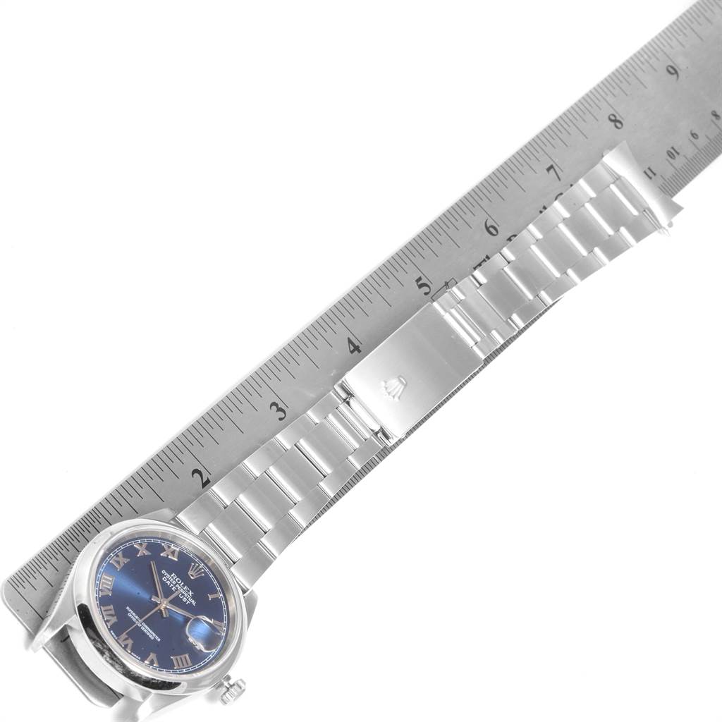 This image shows a Rolex Datejust 16200 Men's Stainless Steel Blue Dial 16200 Men's Stainless Steel Blue Dial watch laid straight with a ruler beside it, revealing the watch face, bracelet, and clasp.