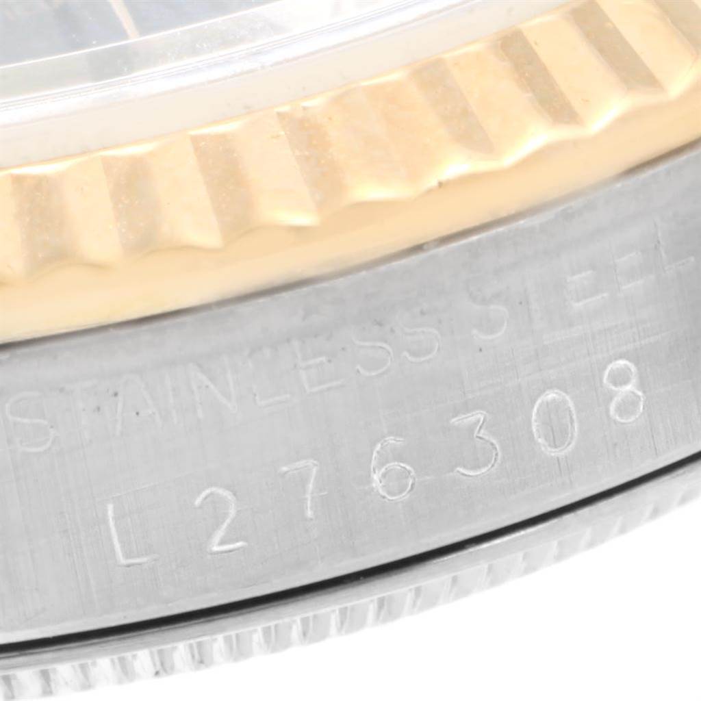 This close-up image shows the bezel and part of the case of a Rolex Datejust 16233 Men's Steel and Gold (two tone) Black Dial 16233 Men's Steel and Gold (two tone) Black Dial watch, displaying the fluted bezel and the serial number.