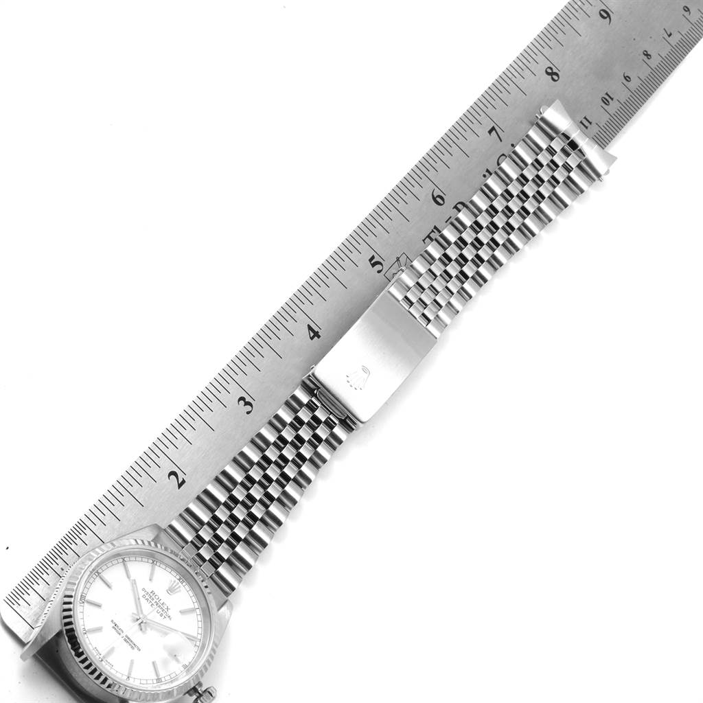 The image shows the Rolex Datejust 16234 Men's Stainless Steel White Dial 16234 Men's Stainless Steel White Dial watch laid flat with its band stretched and a ruler placed alongside it for measurement.