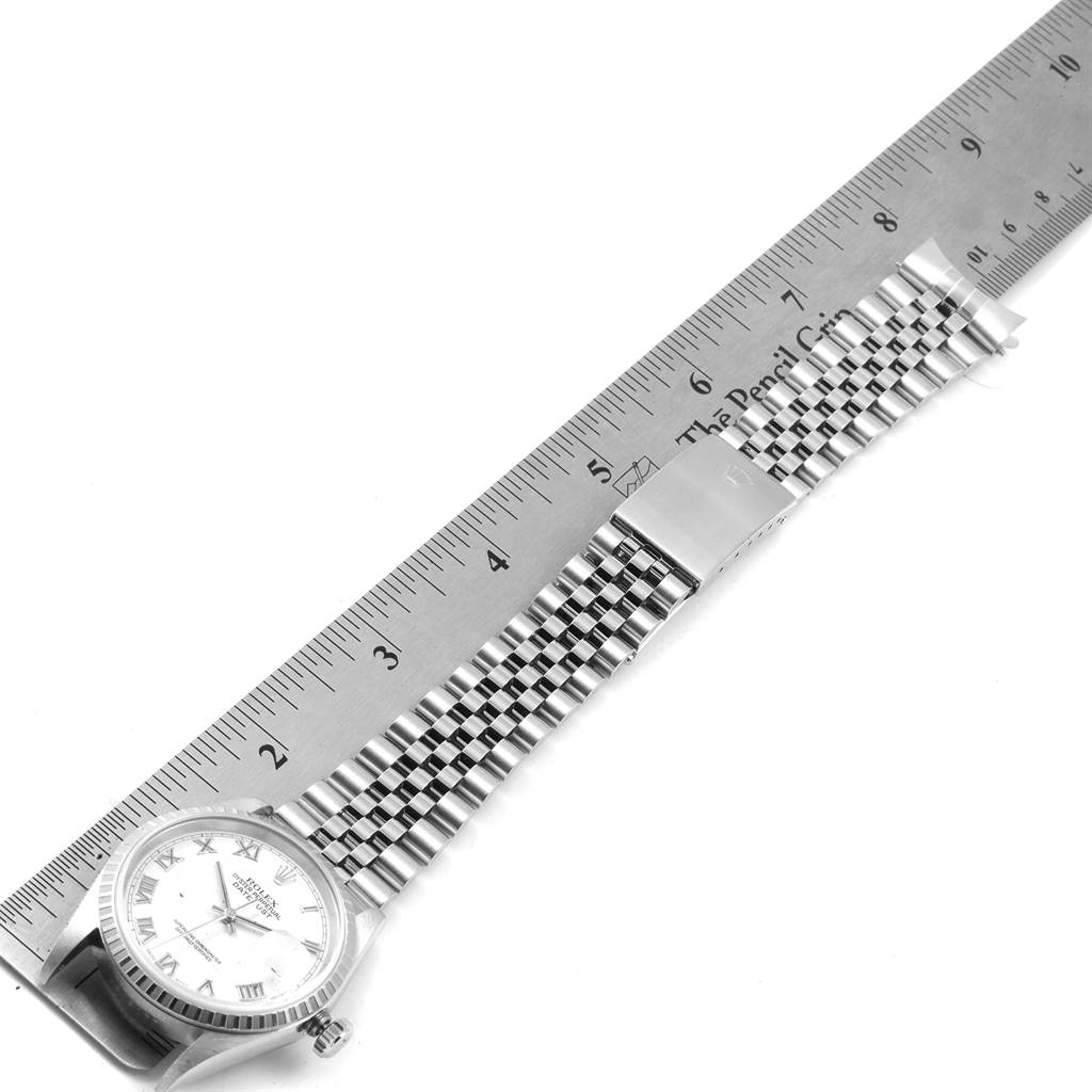 The image shows a top-down view of a Rolex Datejust 16220 Men's Stainless Steel White Dial 16220 Men's Stainless Steel White Dial watch with its bracelet next to a ruler for measurement.