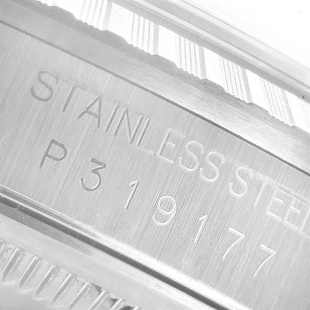 This image shows a close-up of the side of a Rolex Datejust 16220 Men's Stainless Steel White Dial 16220 Men's Stainless Steel White Dial watch, focusing on the stainless steel engraving and serial number.