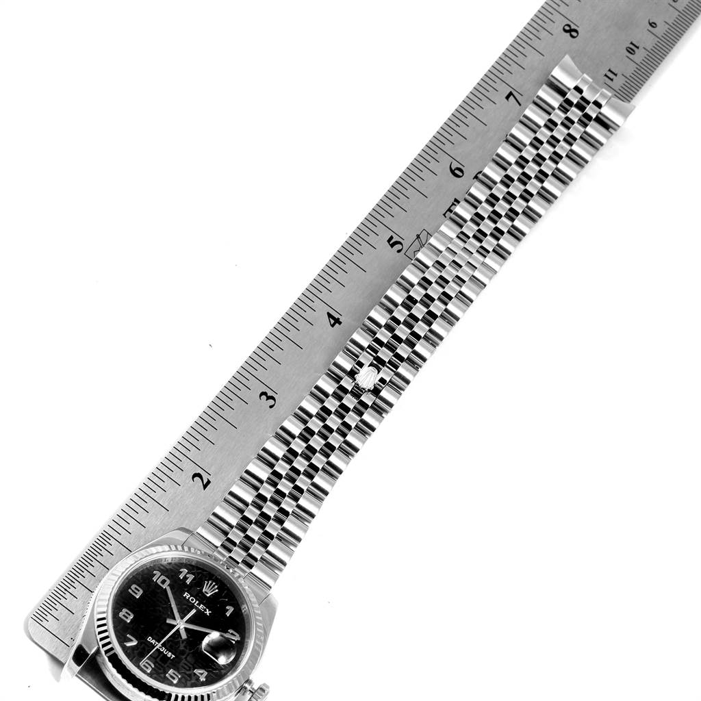 The image shows a top-down view of a Rolex Datejust 116234 Men's Stainless Steel Black Dial 116234 Men's Stainless Steel Black Dial watch model, with the focus on measuring its bracelet length using a ruler.