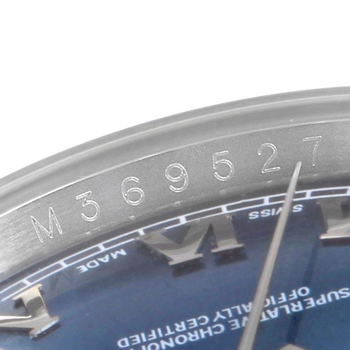 The image shows a close-up of the bezel and a portion of the dial of a Rolex Datejust 116234 Men
s Stainless Steel Blue Dial 116234 Men
s Stainless Steel Blue Dial watch, including serial numbers.