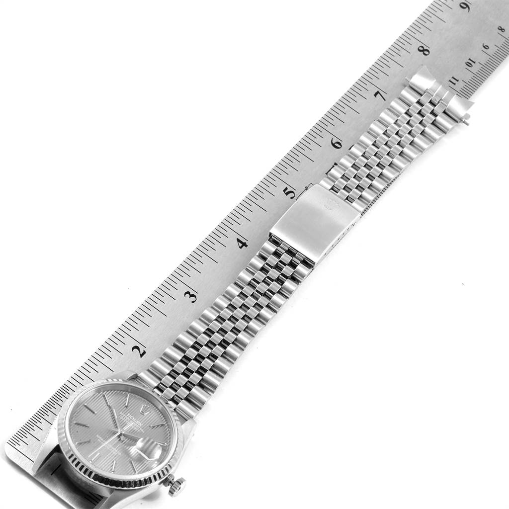 The image shows a Rolex Datejust 16234 Men's Stainless Steel Grey Dial 16234 Men's Stainless Steel Grey Dial watch laid flat alongside a ruler, highlighting both the face and the metal bracelet.