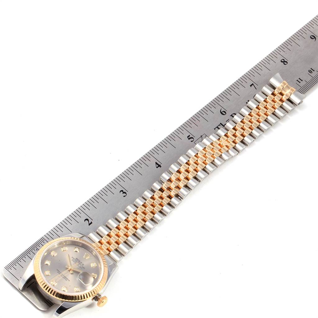 The image shows a Rolex Datejust 116233 Men's Steel and Gold (two tone) Silver Dial 116233 Men's Steel and Gold (two tone) Silver Dial watch from a top view, highlighting its face, bezel, and bracelet against a ruler.