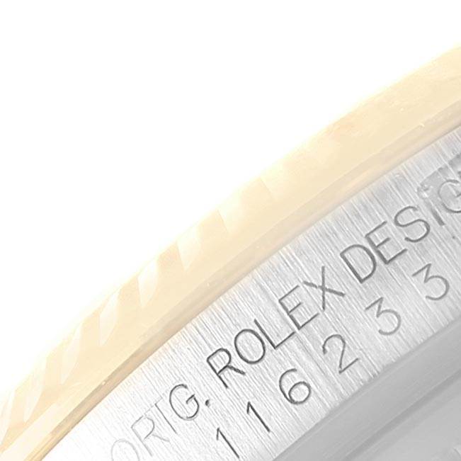 This is a close-up of the edge and engraved writing of the bezel on a Rolex Datejust 116233 Men's Steel and Gold (two tone) Silver Dial 116233 Men's Steel and Gold (two tone) Silver Dial model watch.