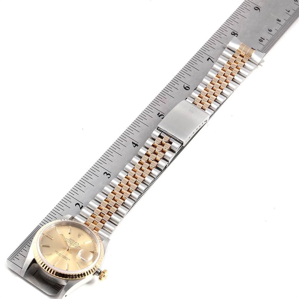 The image shows a side angle of the Rolex Datejust 16233 Men's Steel and Gold (two tone) Champagne Dial 16233 Men's Steel and Gold (two tone) Champagne Dial watch, displaying its face and bracelet next to a ruler for size reference.