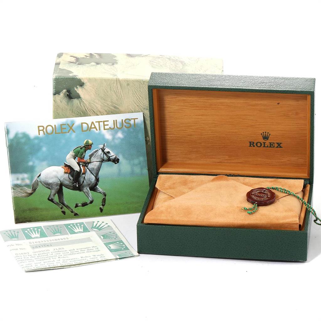 The image shows a Rolex Datejust 16233 Men's Steel and Gold (two tone) Champagne Dial 16233 Men's Steel and Gold (two tone) Champagne Dial watch box, card, booklet, and the dust cloth on an open green and wooden case.