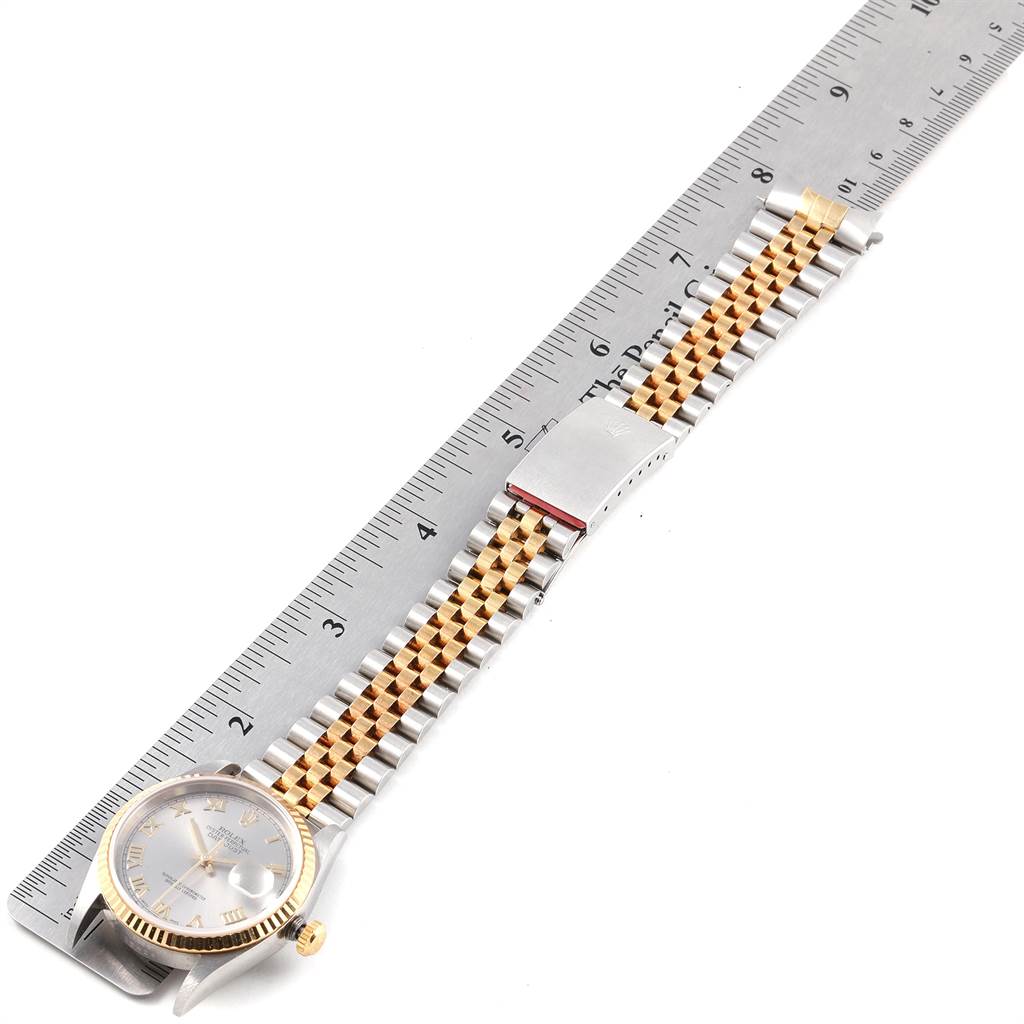 The image shows a Rolex Datejust 16233 Men's Steel and Gold (two tone) Grey Dial 16233 Men's Steel and Gold (two tone) Grey Dial model watch laid flat next to a ruler, displaying its face, two-tone bracelet, and clasp.