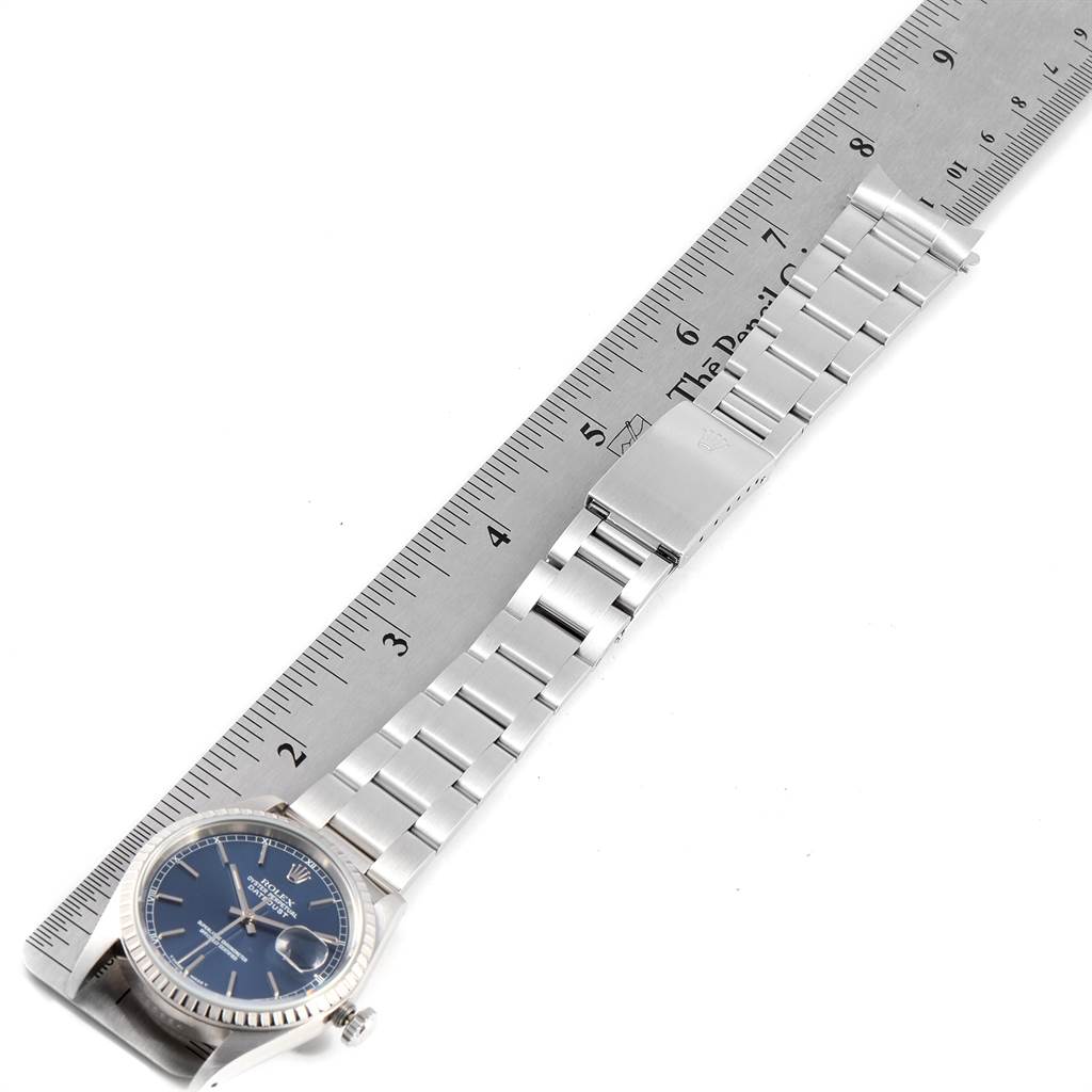 The image shows a Rolex Datejust 16220 Men's Stainless Steel Blue Dial 16220 Men's Stainless Steel Blue Dial watch laid flat next to a ruler, highlighting the watch's face and linked bracelet.