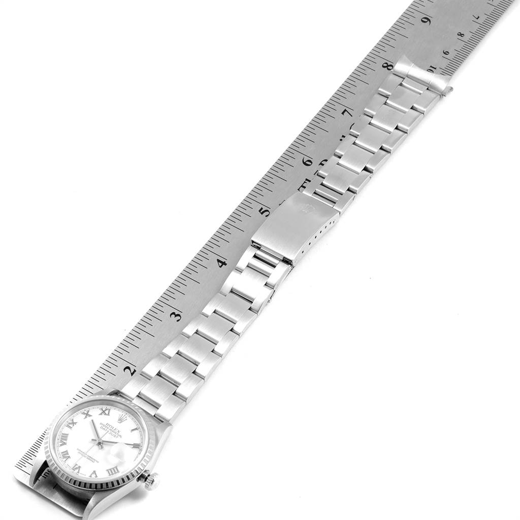 The Rolex Datejust 16220 Men's Stainless Steel White Dial 16220 Men's Stainless Steel White Dial watch, shown from a top-down angle, includes the face and bracelet beside a measuring ruler.