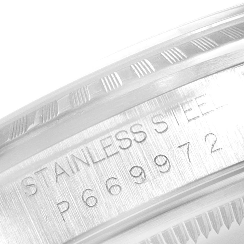 This image shows a close-up of the Rolex Datejust 16220 Men's Stainless Steel White Dial 16220 Men's Stainless Steel White Dial model's stainless steel bezel with engraved markings and serial number.