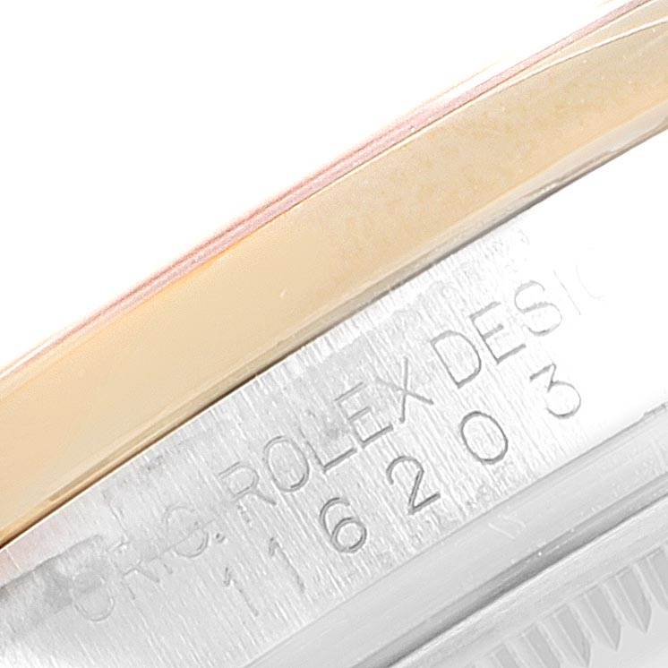 This close-up image of a Rolex Datejust 116203 Men
s Stainless Steel Brown Dial 116203 Men
s Stainless Steel Brown Dial watch shows part of the bezel and the engraved serial number on the case.