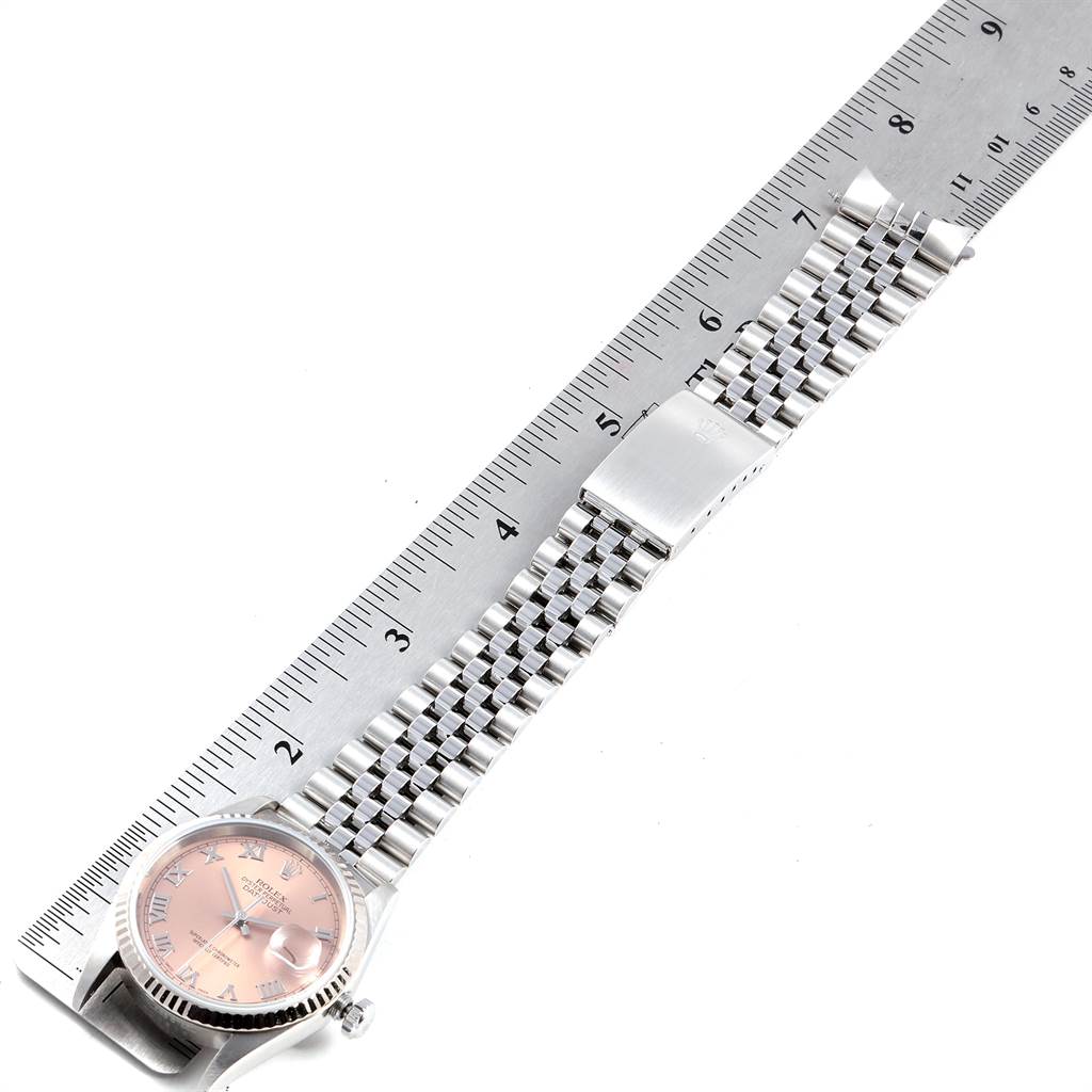 This image shows a Rolex Datejust 16234 Men
s Stainless Steel Pink Dial 16234 Men
s Stainless Steel Pink Dial watch placed next to a ruler, highlighting the dial and the bracelet.
