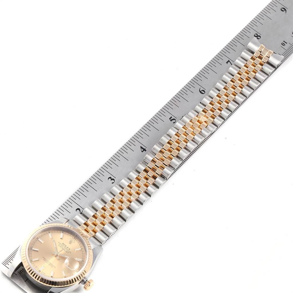 The image shows a Rolex Datejust 116233 Men's Stainless Steel Champagne Dial 116233 Men's Stainless Steel Champagne Dial watch laying flat next to a ruler, displaying the face, bezel, and bracelet.