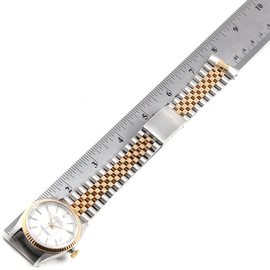 The Rolex Datejust 16233 Men's Steel and Gold (two tone) White Dial 16233 Men's Steel and Gold (two tone) White Dial watch is shown flat with its full bracelet and clasp, alongside a ruler for scale.