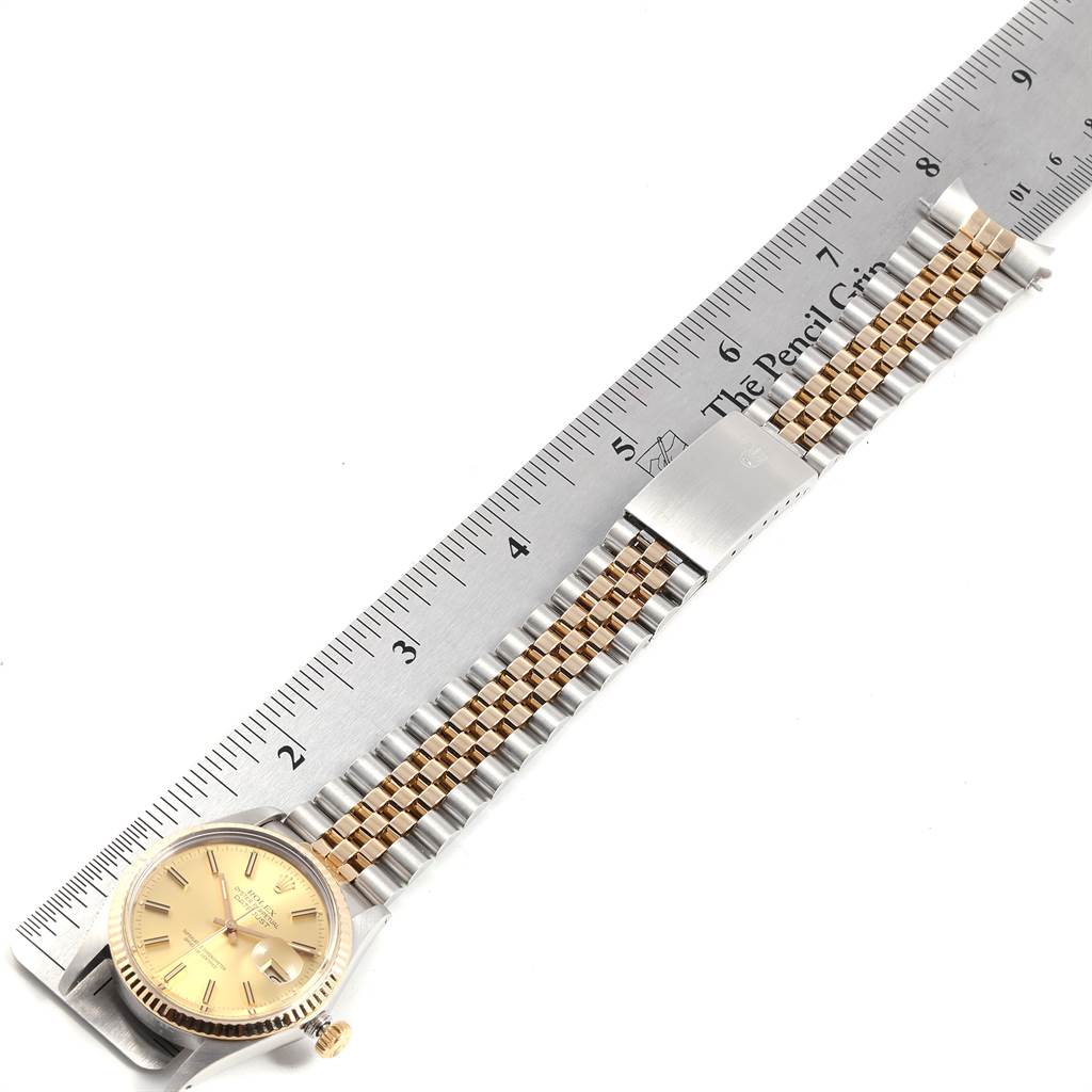 The image shows a Rolex Datejust 16013 Men
s Steel and Gold (two tone) Champagne Dial 16013 Men
s Steel and Gold (two tone) Champagne Dial watch laid flat with its face, bezel, and bracelet visible next to a ruler.