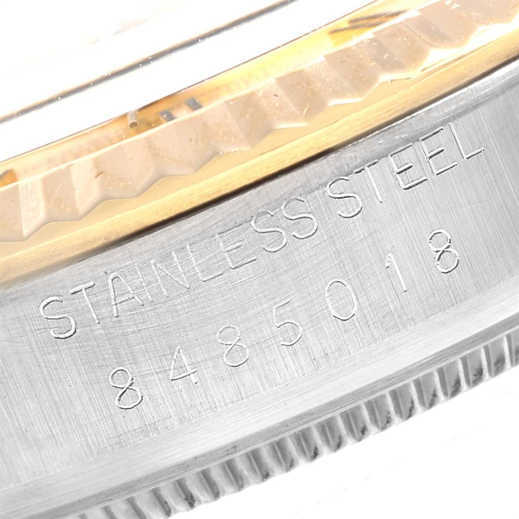 The image shows a close-up of the stainless steel casing and fluted bezel edge of a Rolex Datejust 16013 Men
s Steel and Gold (two tone) Champagne Dial 16013 Men
s Steel and Gold (two tone) Champagne Dial watch, with part of the serial number visible.