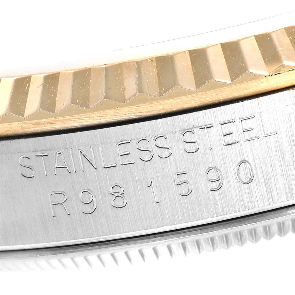 The image shows a close-up of the fluted bezel and the case of a Rolex Datejust 16233 Men
s Steel and Gold (two tone) Champagne Dial 16233 Men
s Steel and Gold (two tone) Champagne Dial watch, highlighting "STAINLESS STEEL" and part of the serial number.