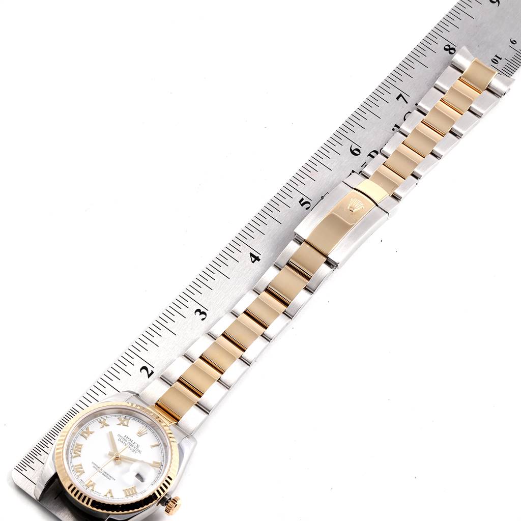 This image shows a Rolex Datejust 116233 Men's Stainless Steel White Dial 116233 Men's Stainless Steel White Dial watch laid flat with its two-tone bracelet extended next to a ruler for measurement.