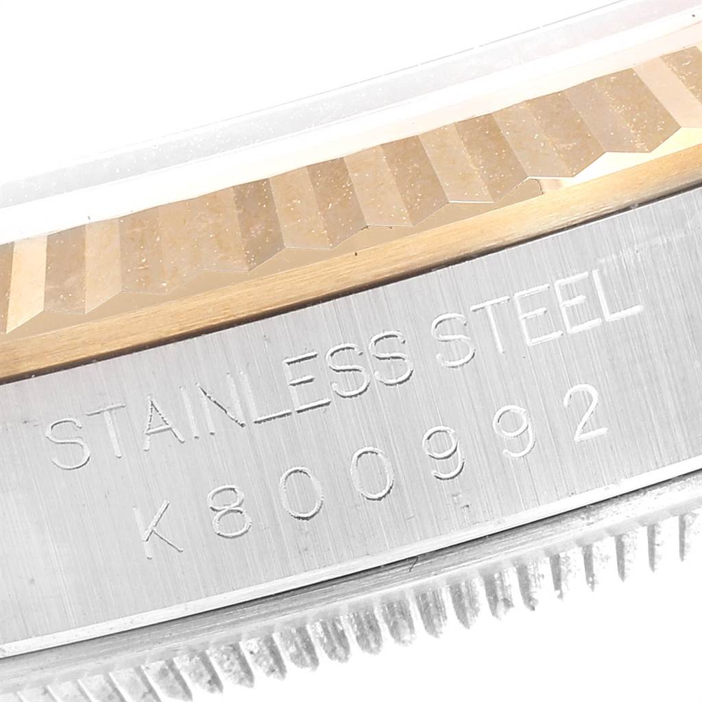 The image shows a close-up of the side of a Rolex Datejust 16233 Men
s Steel and Gold (two tone) Black Dial 16233 Men
s Steel and Gold (two tone) Black Dial watch, highlighting the stainless steel casing and engraved serial number.