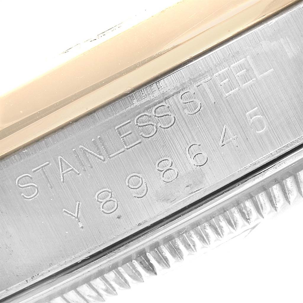 The image shows an angled close-up of the side of a Rolex Datejust 16203 Men's Steel and Gold (two tone) White Dial 16203 Men's Steel and Gold (two tone) White Dial model watch, focusing on the serial number and "Stainless Steel" engraving.