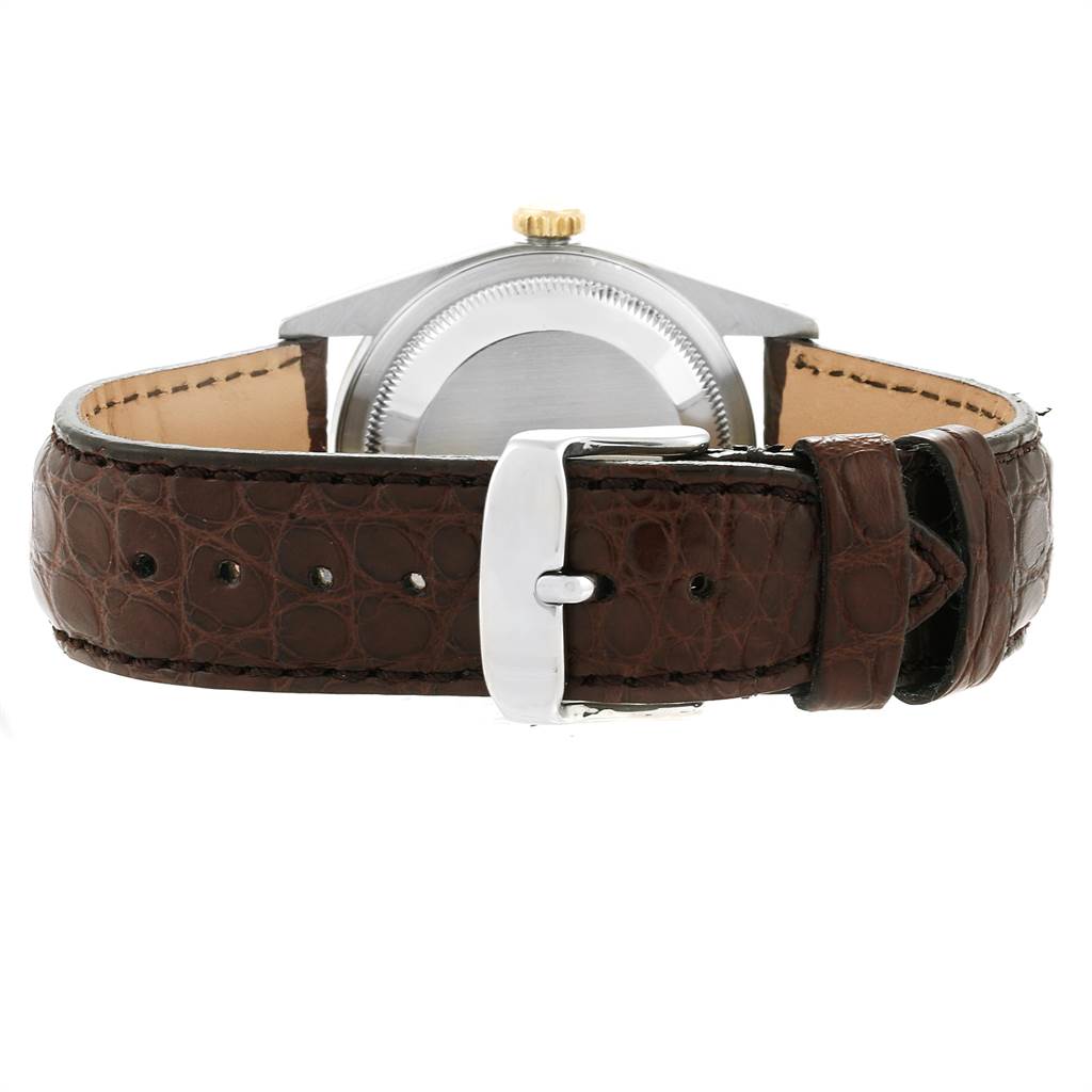 This image shows the back view of a Rolex Datejust 16233 Men
s Steel and Gold (two tone) Champagne Dial 16233 Men
s Steel and Gold (two tone) Champagne Dial watch, focusing on the case back and brown leather strap with a buckle.