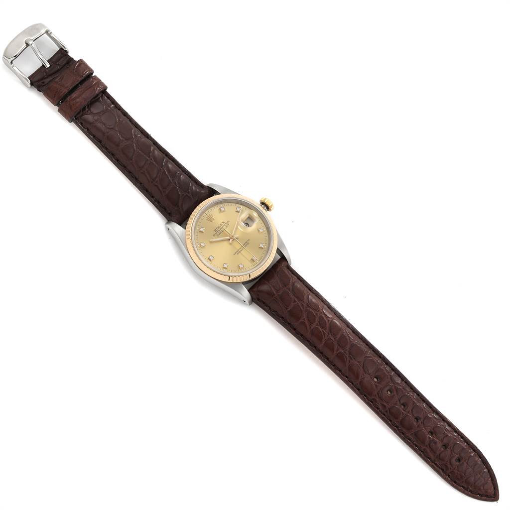 This Rolex Datejust 16233 Men
s Steel and Gold (two tone) Champagne Dial 16233 Men
s Steel and Gold (two tone) Champagne Dial watch is shown from a top-down angle, featuring a beige dial and a brown leather strap.