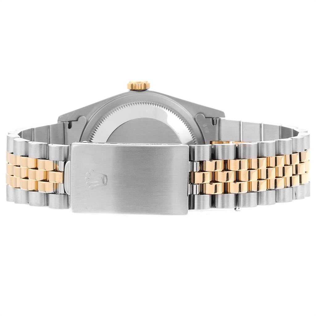 The image shows the back view of a Rolex Datejust 16233 Men
s Steel and Gold (two tone) Champagne Dial 16233 Men
s Steel and Gold (two tone) Champagne Dial, highlighting its clasp and two-tone metal bracelet.