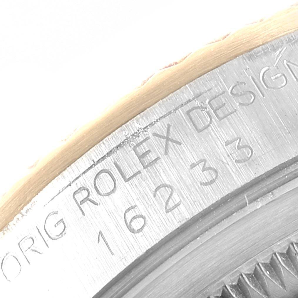 The image shows a close-up of the engraved bezel and part of the case of a Rolex Datejust 16233 Men
s Steel and Gold (two tone) Beige Dial 16233 Men
s Steel and Gold (two tone) Beige Dial watch.