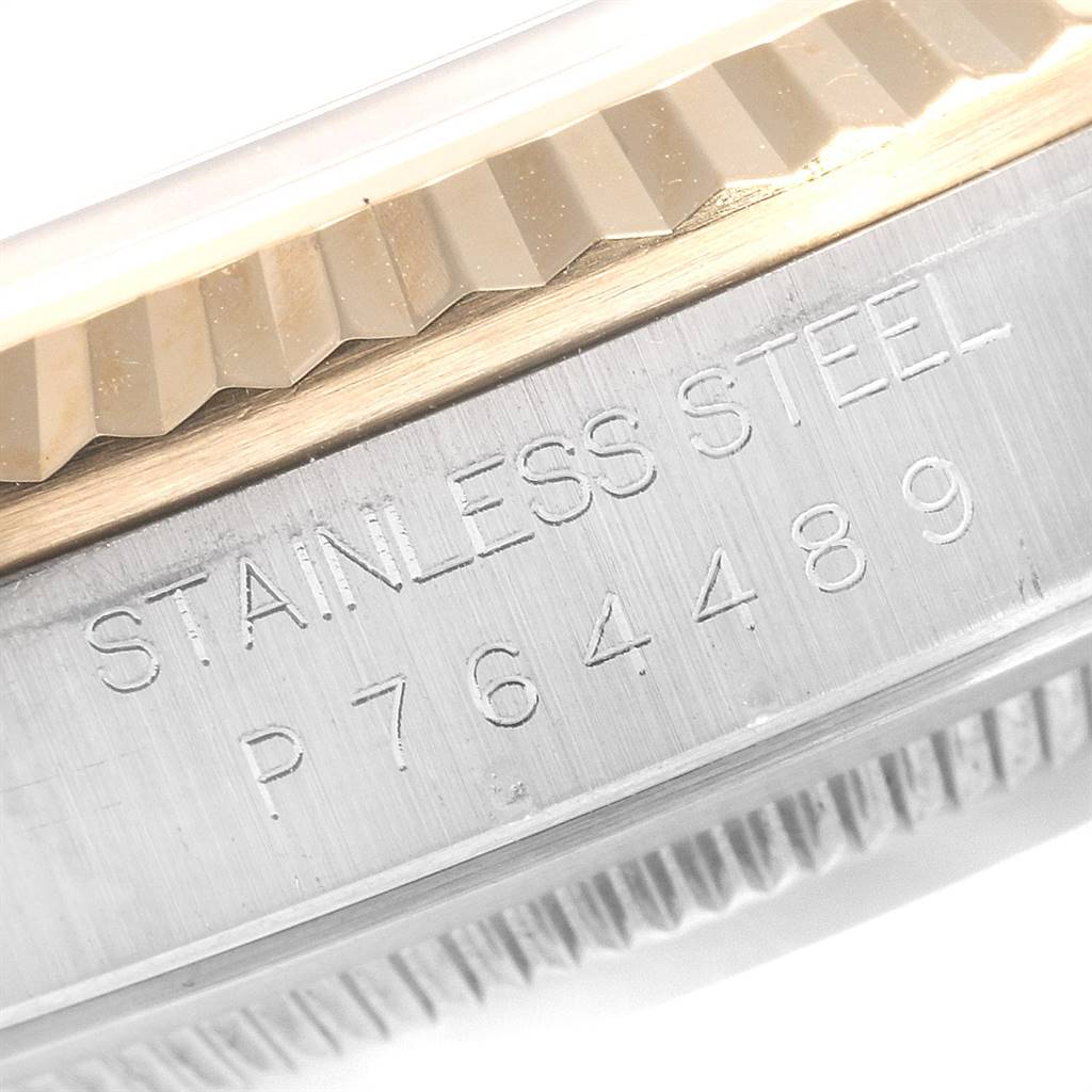 This close-up image shows the fluted bezel and the "STAINLESS STEEL" inscription with a serial number around the case of the Rolex Datejust 16233 Men
s Steel and Gold (two tone) Champagne Dial 16233 Men
s Steel and Gold (two tone) Champagne Dial watch.