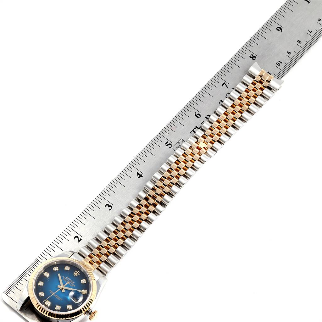 This image shows a Rolex Datejust 116233 Men
s Stainless Steel Blue Dial 116233 Men
s Stainless Steel Blue Dial watch with a blue dial and two-tone bracelet, placed alongside a ruler for measurement.